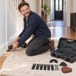 Man kneeling on a dust sheet using the cordless multi-tool at a skirting board