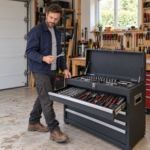 Man taking a spanner from the top drawer of the tool chest